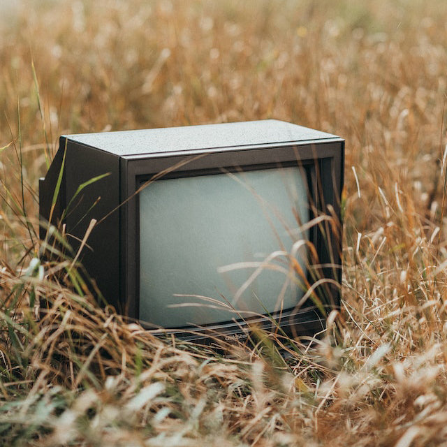 Old television sitting on a patch of grass