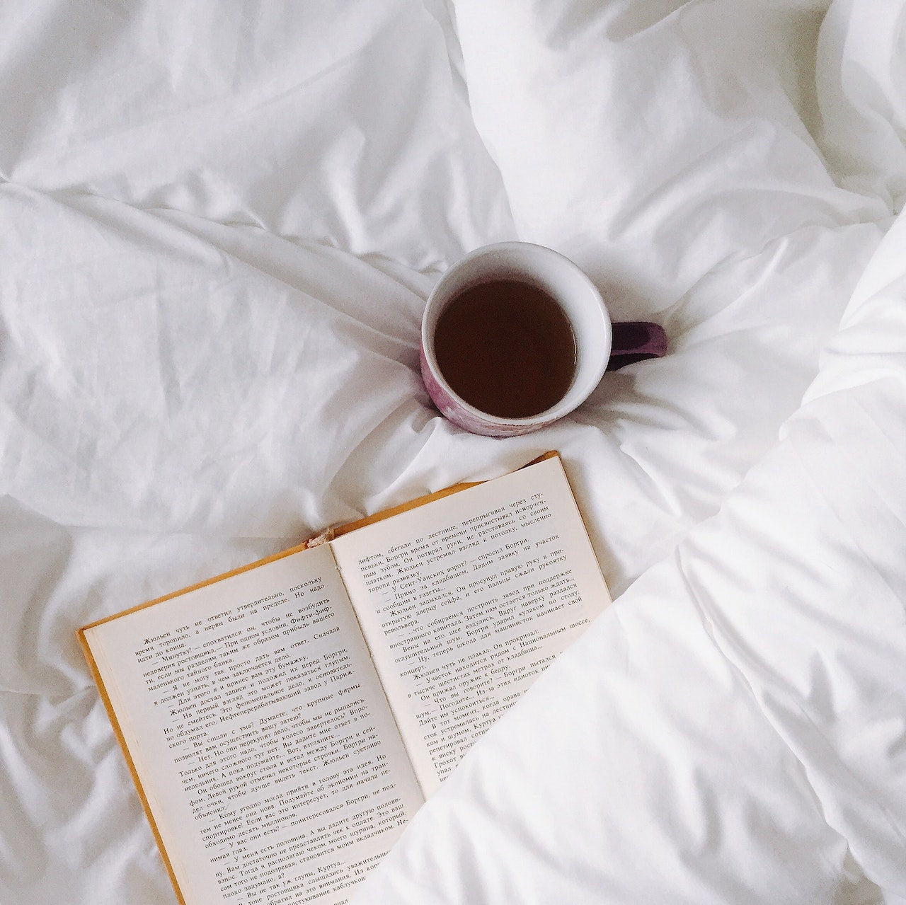 A cup of tea and book on bed